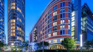 A modern hotel with a curved facade, multiple floors, and large windows. - Radisson Blu Hotel, London Canary Wharf East (London)