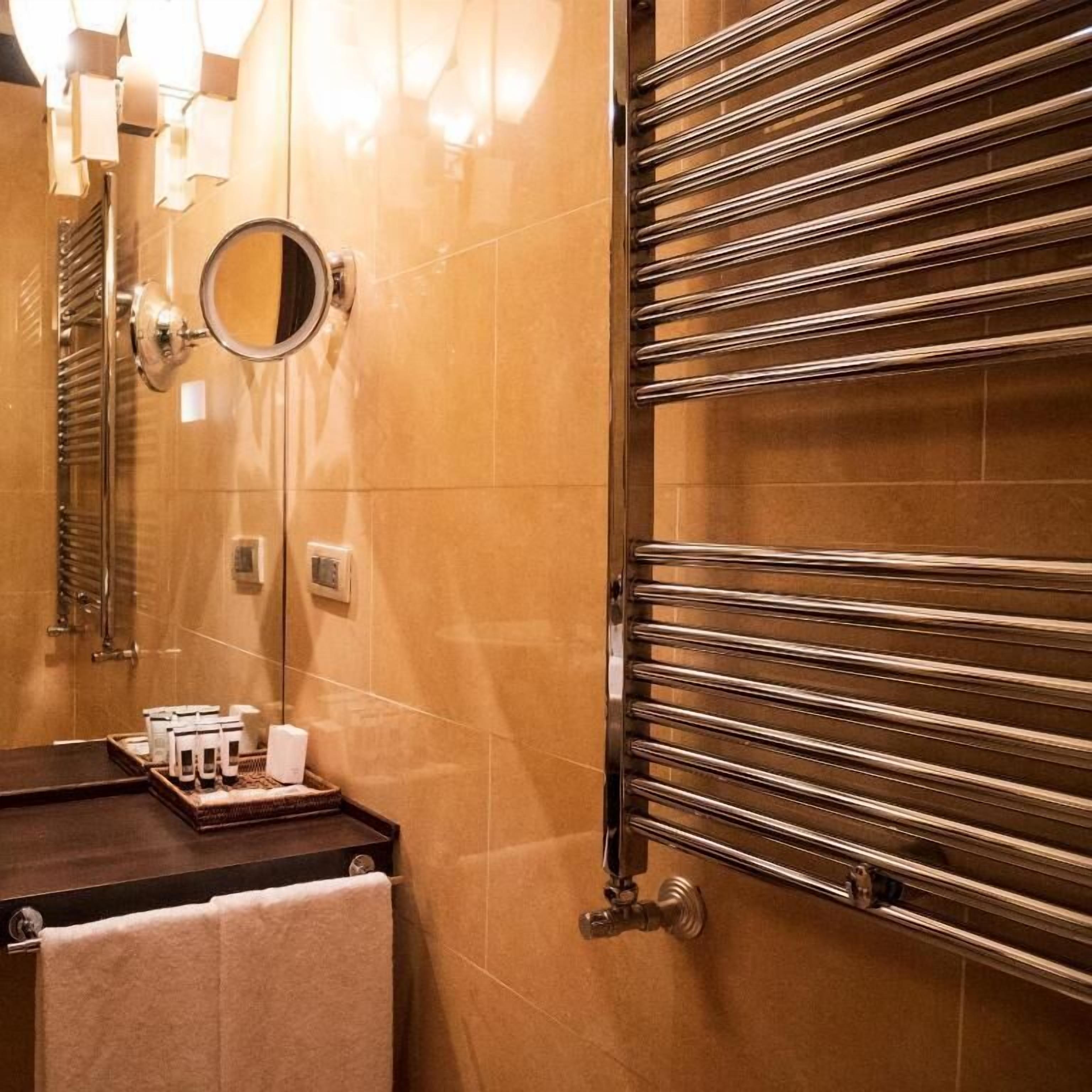 A bathroom with a mirror, towel rack, and toiletries.