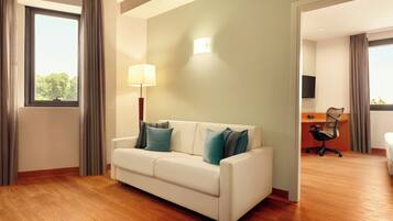 A modern hotel room with a white sofa, a desk, and a chair.