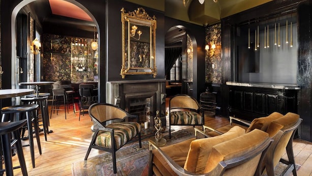 Een luxueus interieur met een bar, zitgedeelte en een open haard.