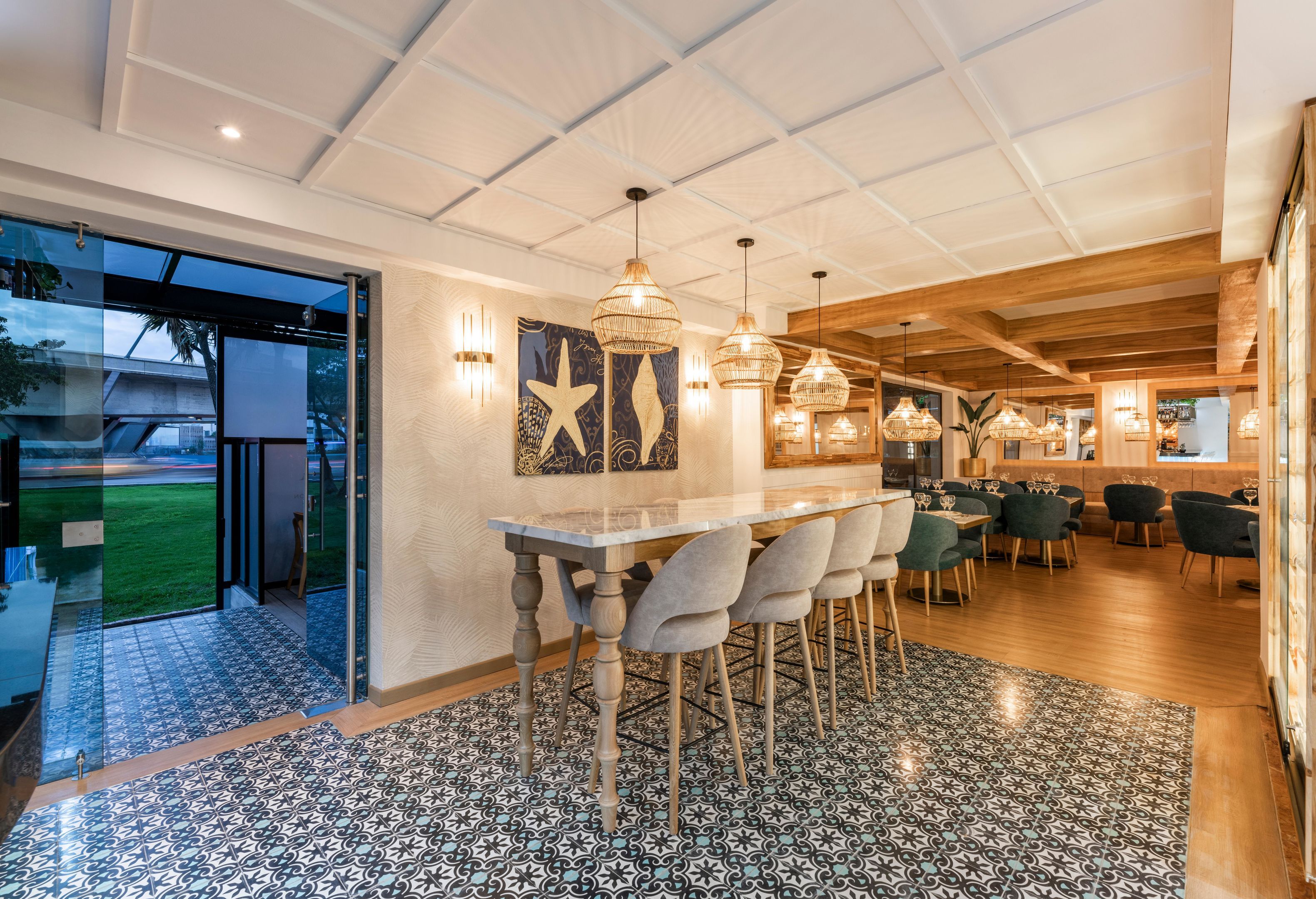 Un área de comedor moderna con un separador de vidrio, una barra y un conjunto de asientos.