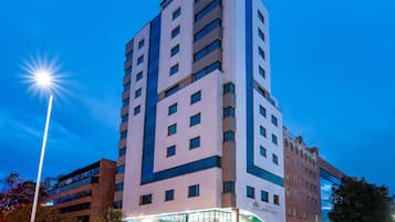 Un hotel de varios pisos con fachada moderna, amplias ventanas y una entrada destacada.
