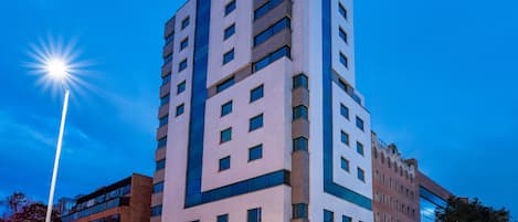 Een hotel met meerdere verdiepingen, een moderne gevel, grote ramen en een opvallende entree.