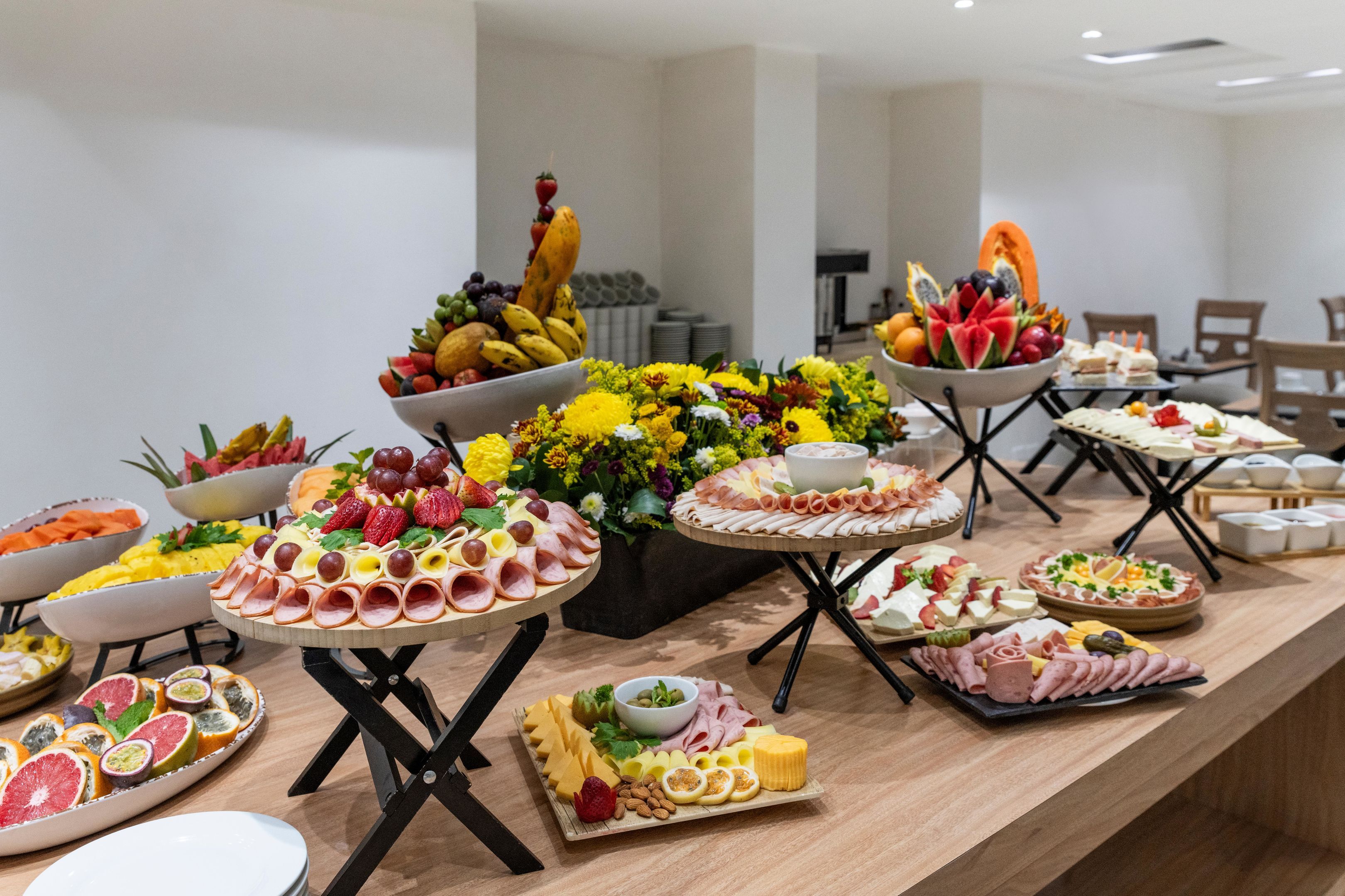 Una mesa de buffet con diversas opciones de comida y un centro de mesa floral.