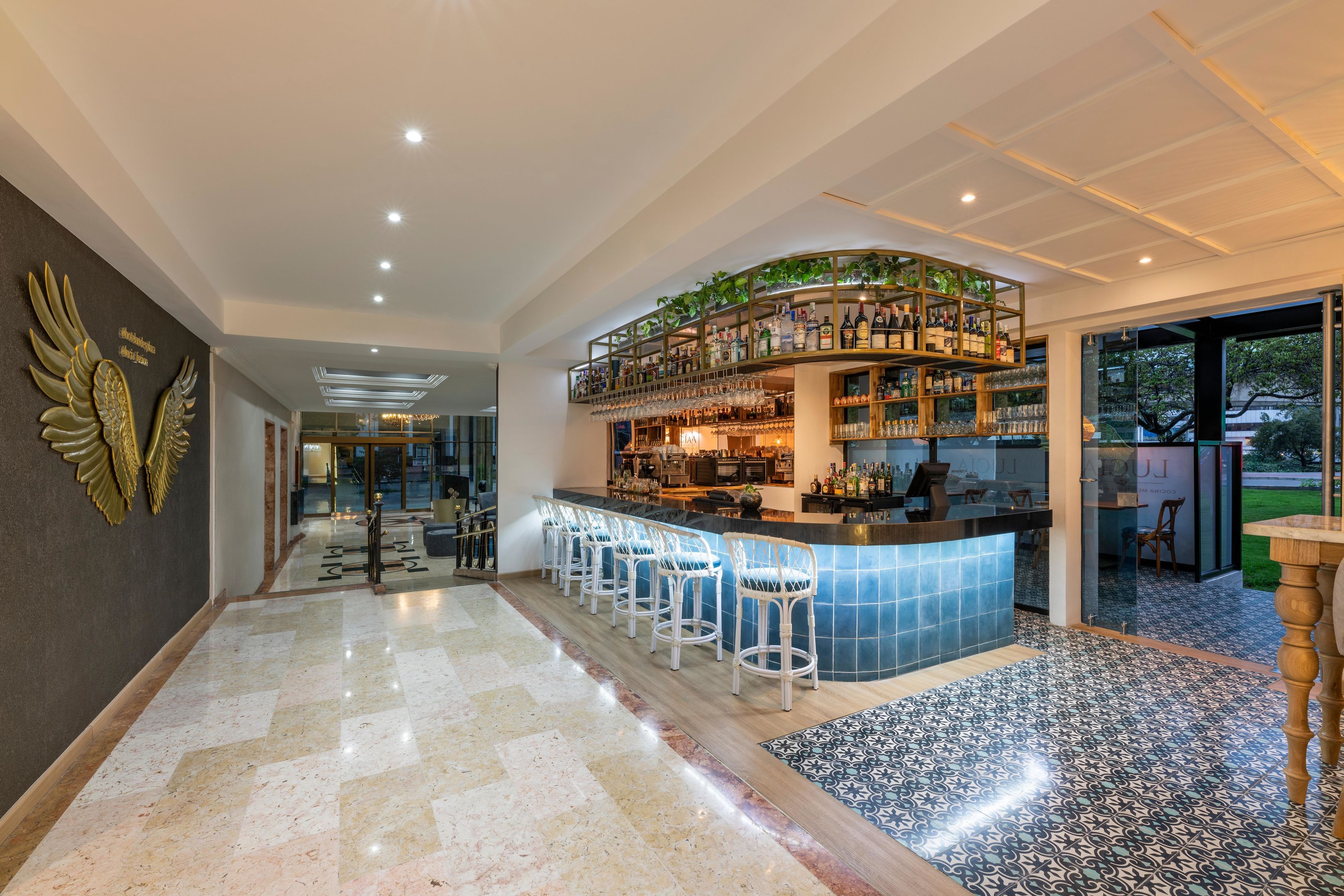 A bar area with a curved counter, bar stools, and a variety of bottles and glasses.