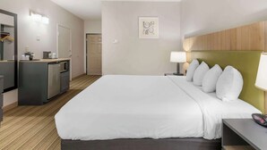 A hotel room with a large bed, a desk with a lamp, a kitchenette, and a bathroom. - Country Inn & Suites by Radisson, Columbia, MO (Columbia)