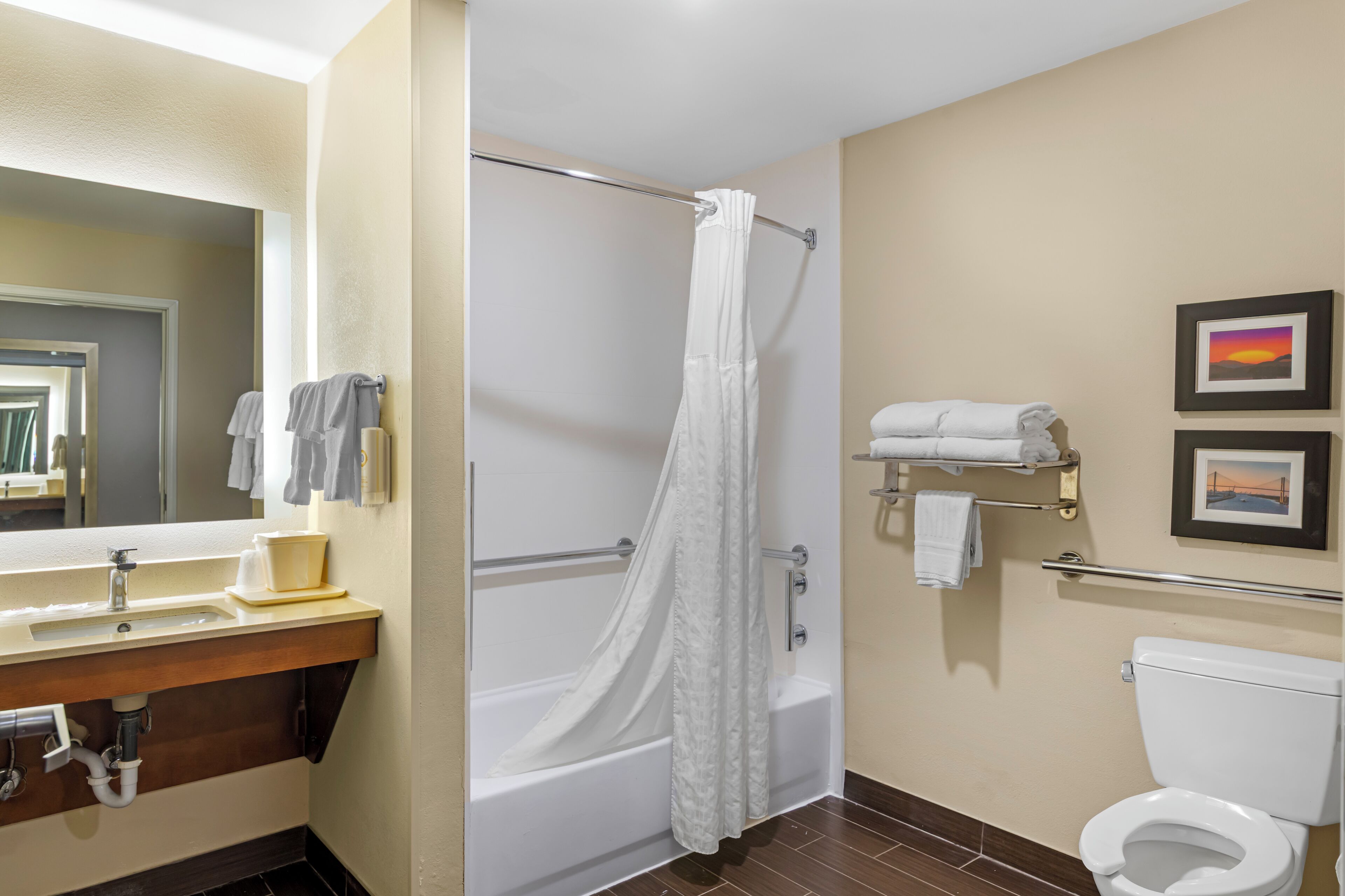 A bathroom with a bathtub, a toilet, a sink, and a mirror.