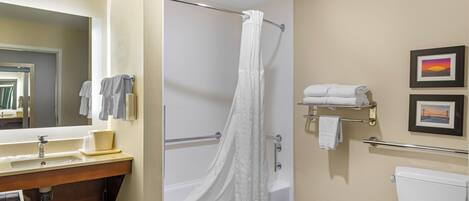 A bathroom with a bathtub, a toilet, a sink, and a mirror.