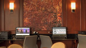 A conference room with two Dell computers, a large autumn-themed painting, and two wall-mounted lamps. - Courtyard by Marriott Hadley Amherst (Hadley)
