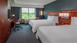 A hotel room with two beds, a desk with a chair, a TV, and a large window with curtains. - Courtyard by Marriott Hadley Amherst (Hadley)