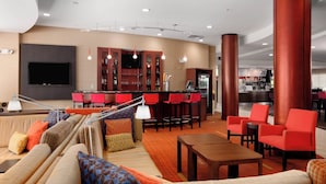 A modern hotel lobby with a bar area, seating, and a television. - Courtyard by Marriott Wall at Monmouth Shores Corporate Park (Neptune City)