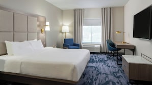 A hotel room with a large bed, a desk, a chair, a TV, and a window with curtains. - Fairfield Inn & Suites by Marriott Lafayette South (Lafayette)