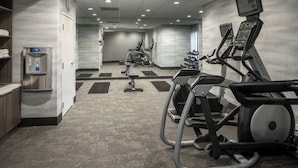 A gym with treadmills, elliptical machines, and a water dispenser. - Fairfield Inn & Suites by Marriott Lafayette South (Lafayette)