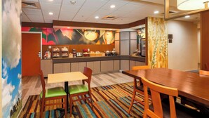 A hotel room with a dining area, a kitchen counter with food items, and a colorful mural on the wall. - Fairfield Inn & Suites Temecula by Marriott (Temecula)