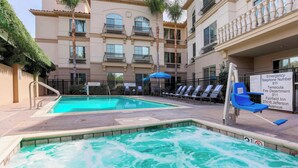 A swimming pool with a water slide, lounge chairs, and a sign with emergency contact numbers. - Fairfield Inn & Suites Temecula by Marriott (Temecula)