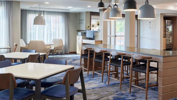 A hotel lobby with a bar area, seating, and a reception desk. - Fairfield Inn & Suites by Marriott Burlington (Burlington)