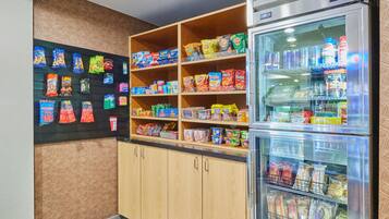 Zona de exhibición de snacks con diversas opciones empaquetadas y una sección refrigerada.