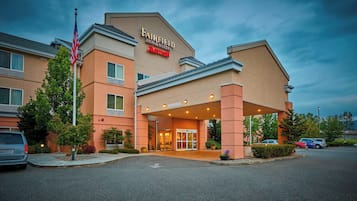 Un hotel Fairfield Inn & Suites by Marriott con una entrada moderna y un estacionamiento.