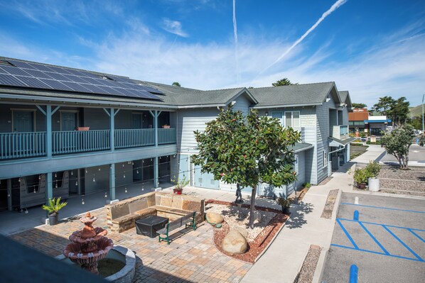 A courtyard with a fountain, seating area, and a tree. - Morro Shores Inn And Suites (Morro Bay)