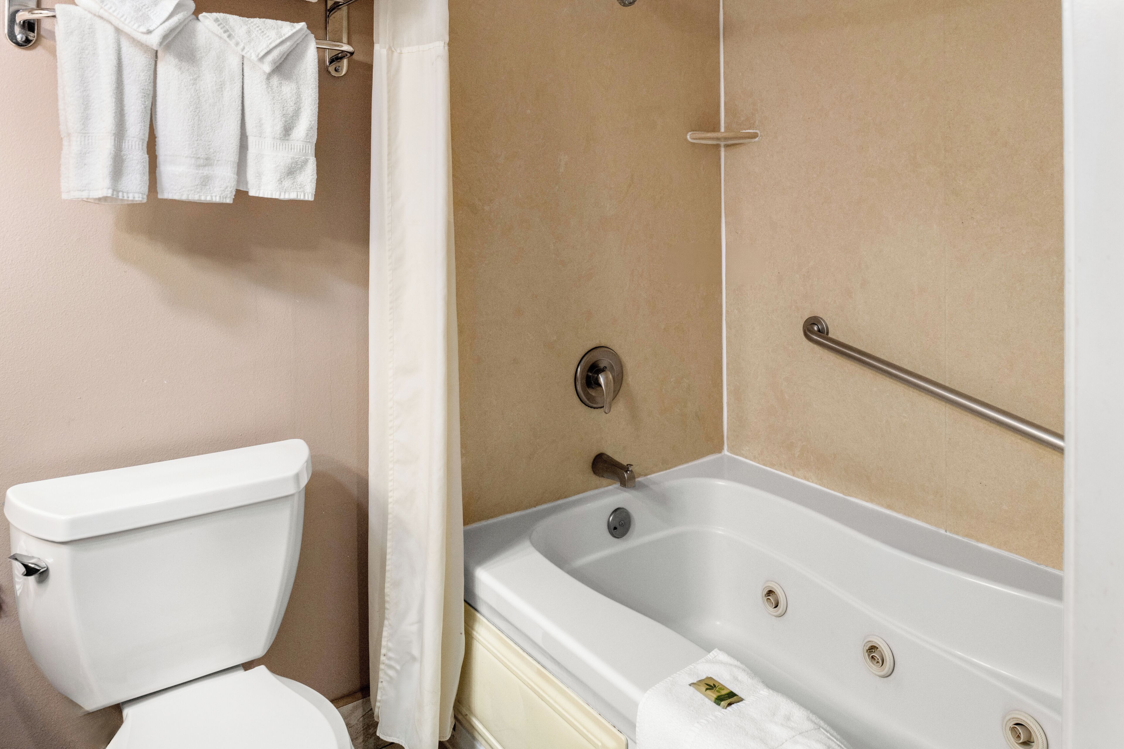 Ein Badezimmer mit Toilette, Badewanne und Handtuchhalter.