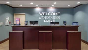 A reception desk with a "WELCOME TO THE HOOSIER STATE" sign, a phone, and a Hilton Honors sign.