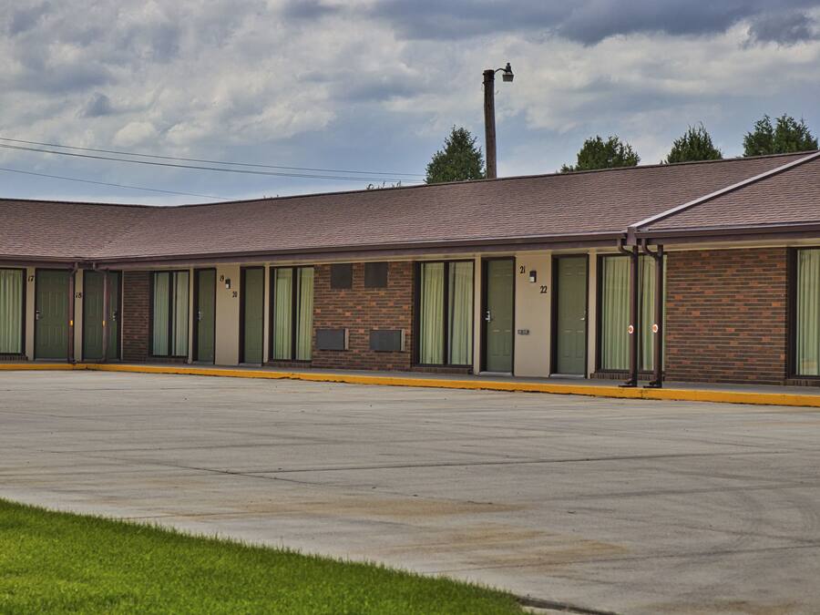 Ein Motel mit einer Reihe von Zimmern, jedes mit einer Nummer und einem Fenster.