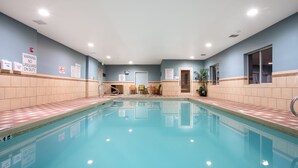 An indoor swimming pool with tiled walls, a lifeguard warning sign, and a reception area with chairs and a plant. - Holiday Inn Express & Suites Tucumcari by IHG (Tucumcari)