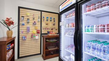 A retail display area with shelves stocked with snacks and a refrigerated section with bottled water.