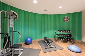 A gym with exercise equipment, a blue exercise ball, a bench, and a rack of dumbbells. - Holiday Inn Express & Suites Corona by IHG (Corona)