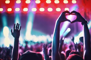 A crowd at a concert with raised hands and a heart shape made by two hands. - Holiday Inn Express & Suites Corona by IHG (Corona)