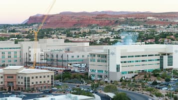A commercial area with multiple buildings, including a hotel with a prominent entrance and a large parking lot.