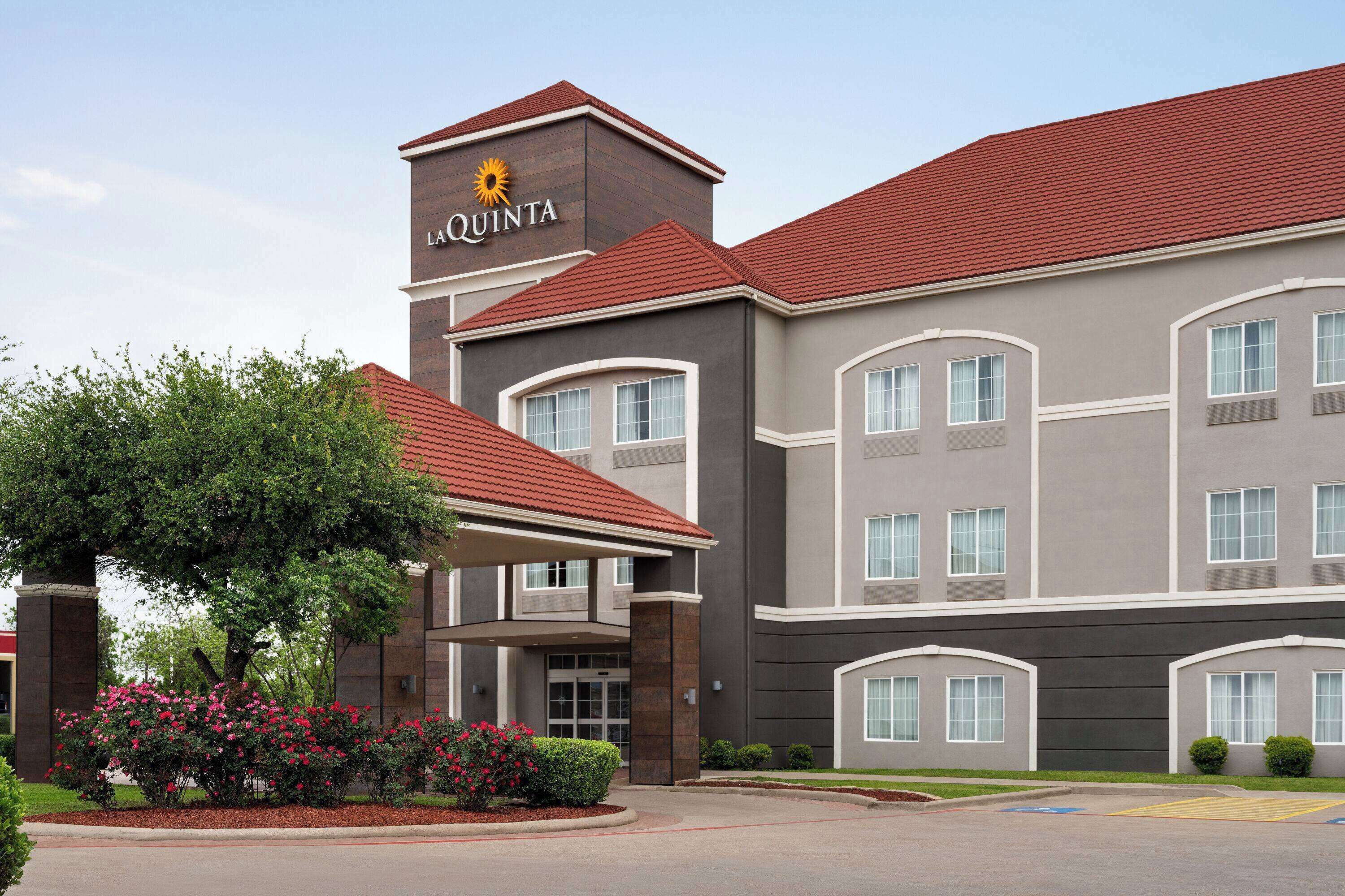 A hotel with a modern design, featuring a prominent 'La Quinta' sign on the building.