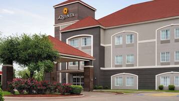 A hotel with a modern design, featuring a prominent 'La Quinta' sign on the building.