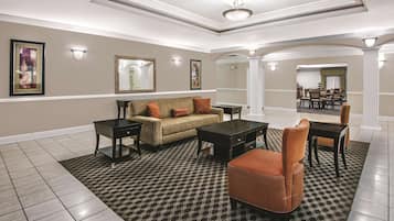 Relax in our spacious lobby with a comfortable seating area, coffee table, and artwork on the walls.