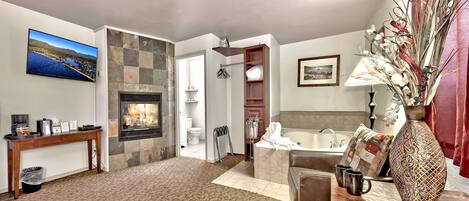 A spacious living area with a fireplace, a television, a comfortable seating area, and a view of the outdoors.