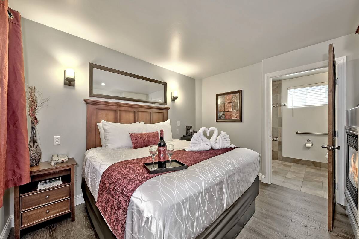 A neatly arranged hotel room with a bed, bedside table, and a mirror.