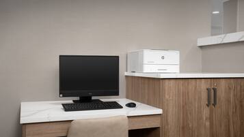 A modern office desk with a computer, keyboard, and mouse.