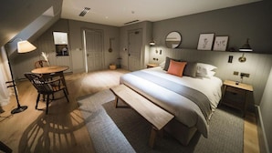 A bedroom with a bed, bedside tables, a desk with a chair, a lamp, and a mirror on the wall. - Highfield Park (Hook)