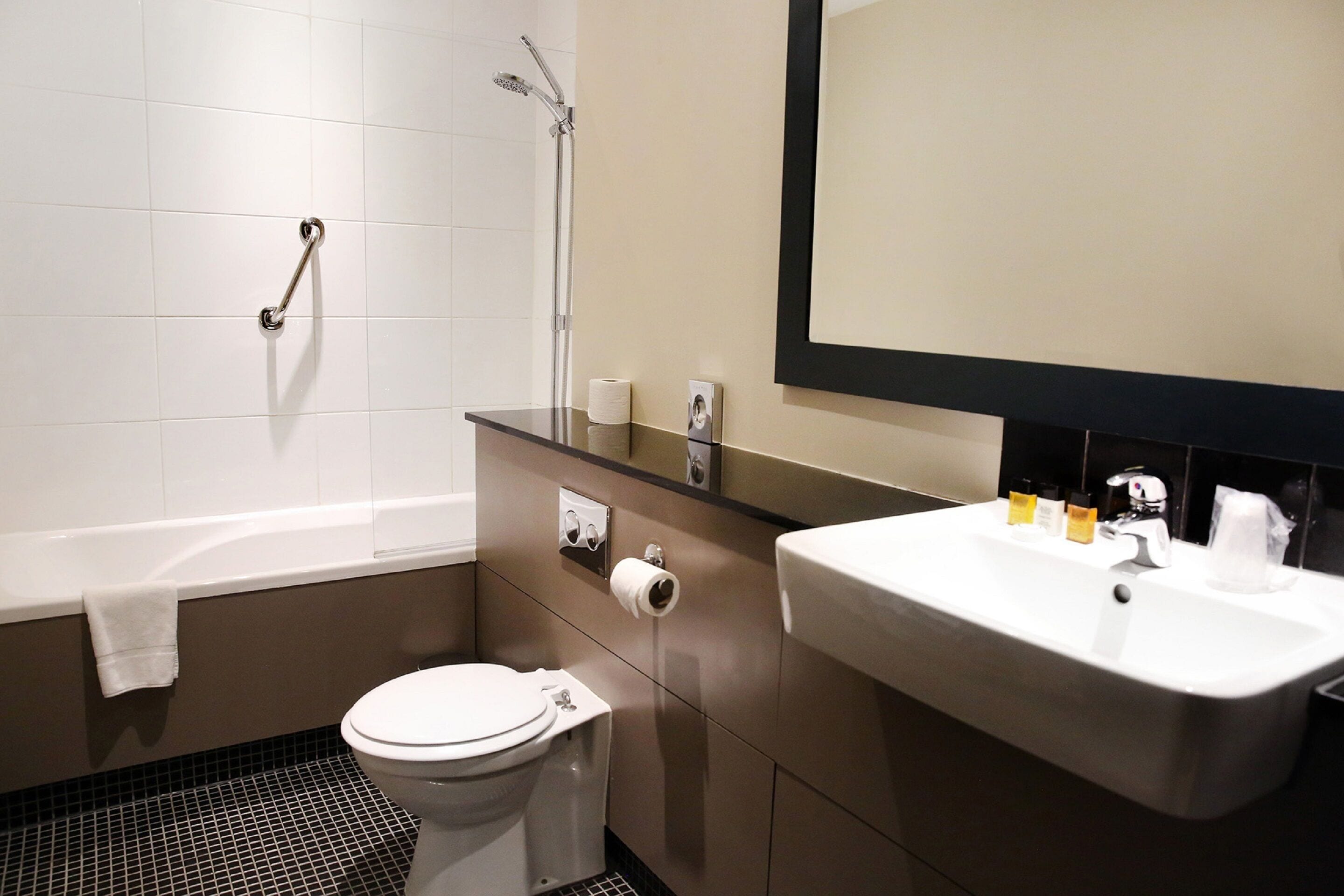 A modern bathroom with a bathtub, toilet, and sink.