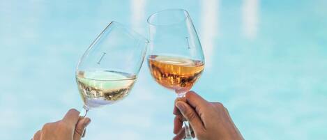 Two hands holding wine glasses with a blurred background.