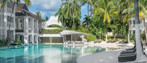 Una piscina al aire libre, sillones reclinables de piscina