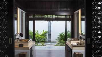 Bathroom features two sinks with marble countertops, a mirror, and a faucet.