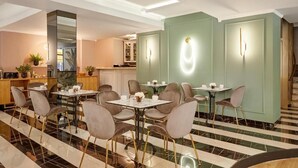 A modern dining area with striped flooring, multiple tables, and chairs. - Hotel Luxembourg (Thessaloniki)