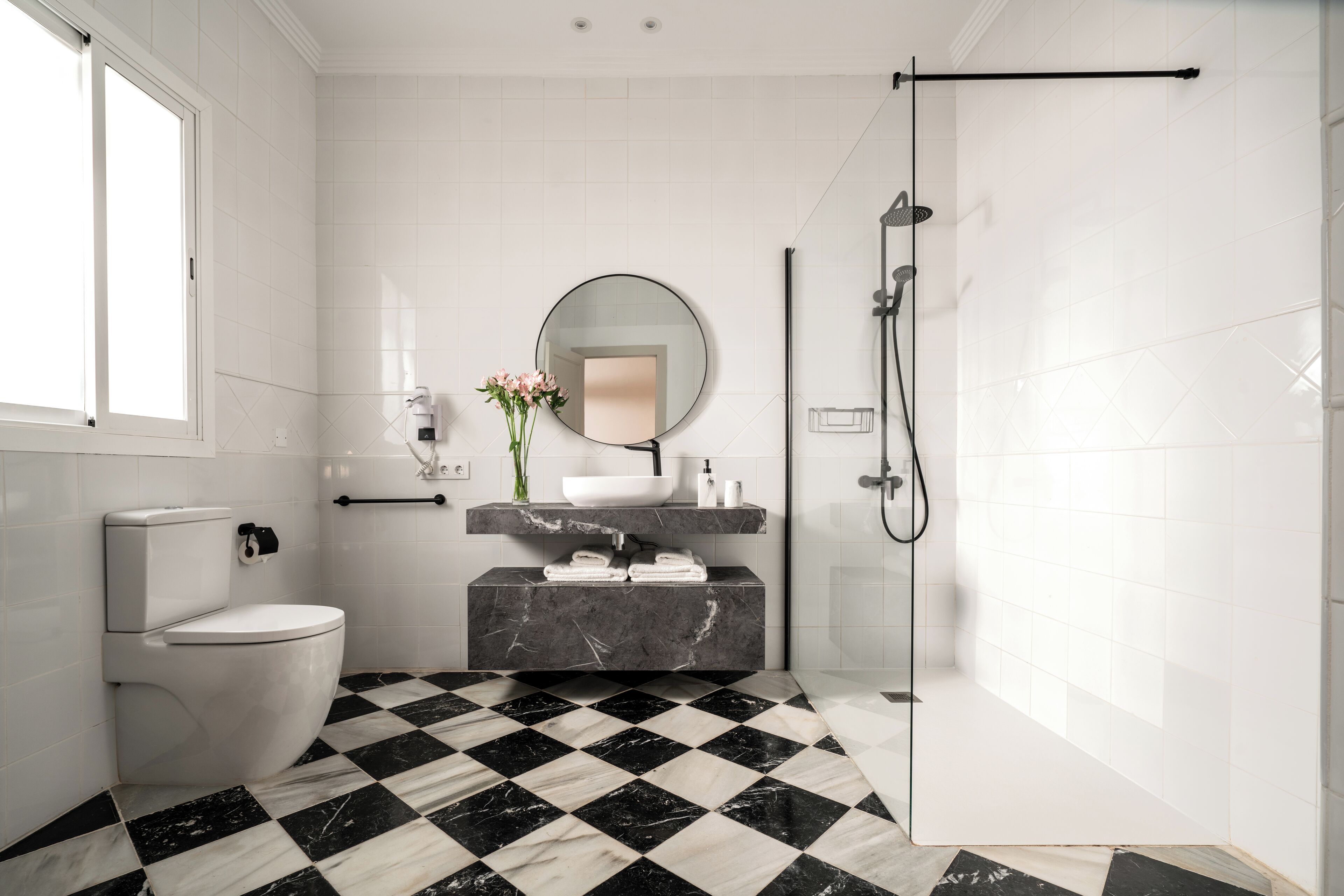 Un baño con inodoro, lavamanos y ducha.