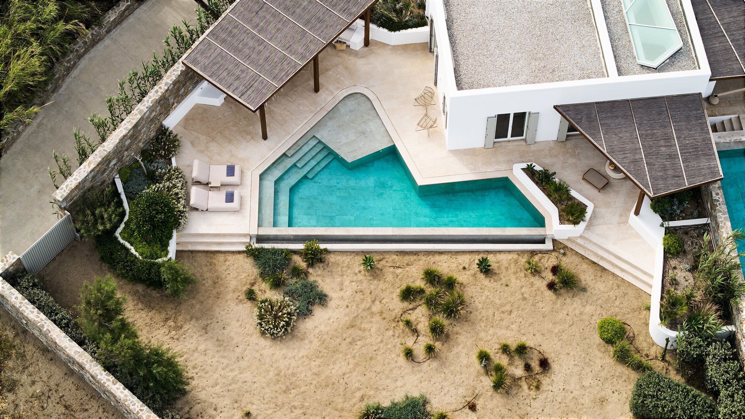 A modern house with a swimming pool, outdoor seating, and a landscaped garden.