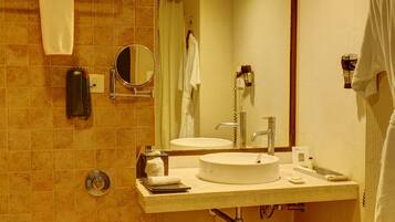 A bathroom with a toilet, sink, mirror, and towel rack.