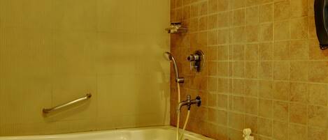 A bathroom with a bathtub, toilet, and a towel rack.