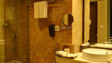 Un baño moderno con ducha de vidrio, inodoro, lavamanos y espejo.