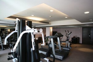 Ett gym med konditionsmaskiner, styrketräningsmaskiner och ett löpband.