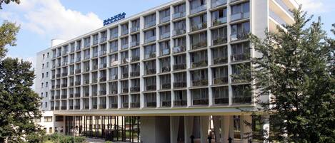 Un hôtel moderne doté d’une série de balcons disposés en réseau, d’une entrée couverte et d’une pelouse bien entretenue.